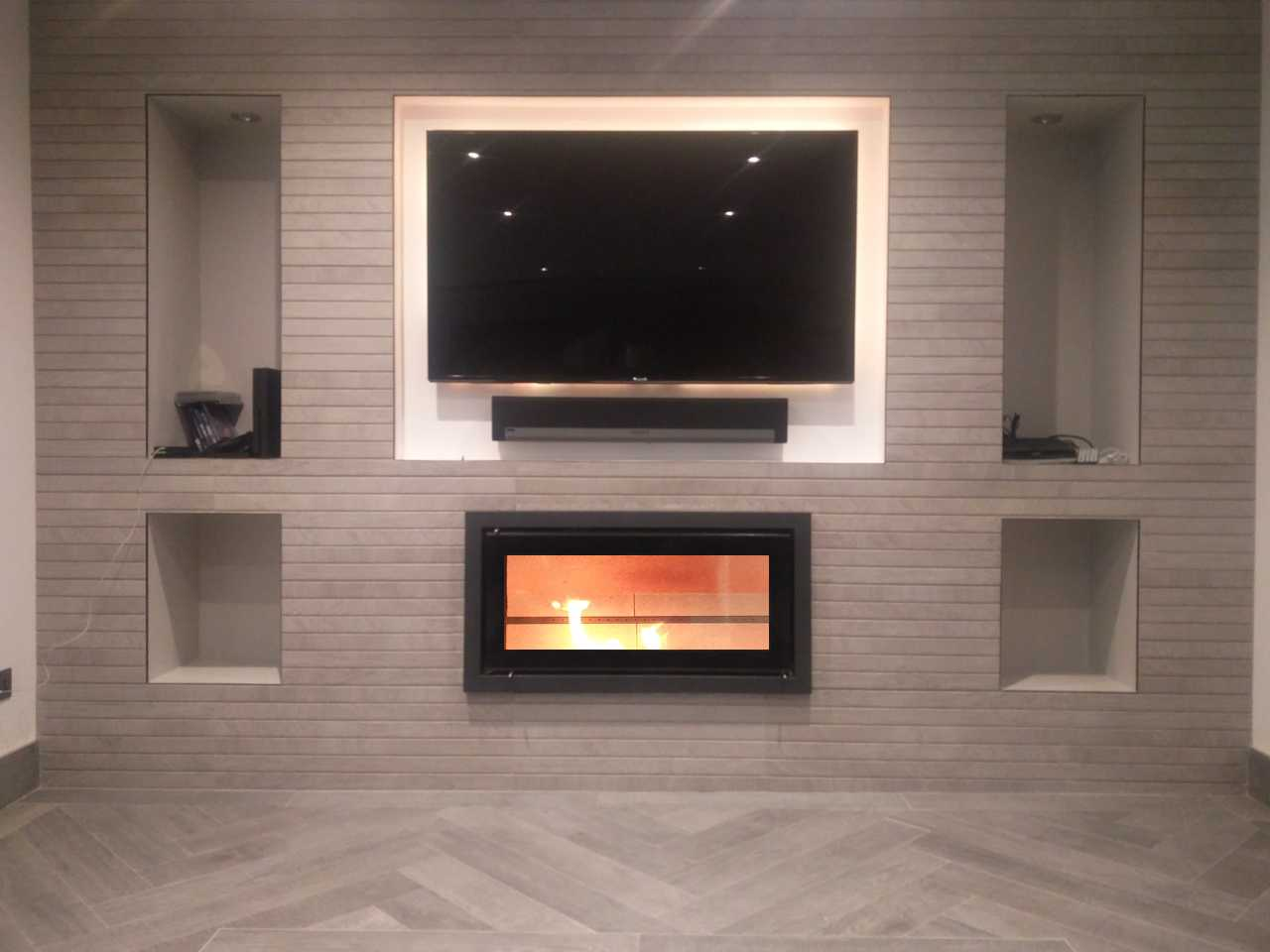 Bespoke fireplace design and install, tiled media wall with inset wood burning fire, TV recess and alcove niches